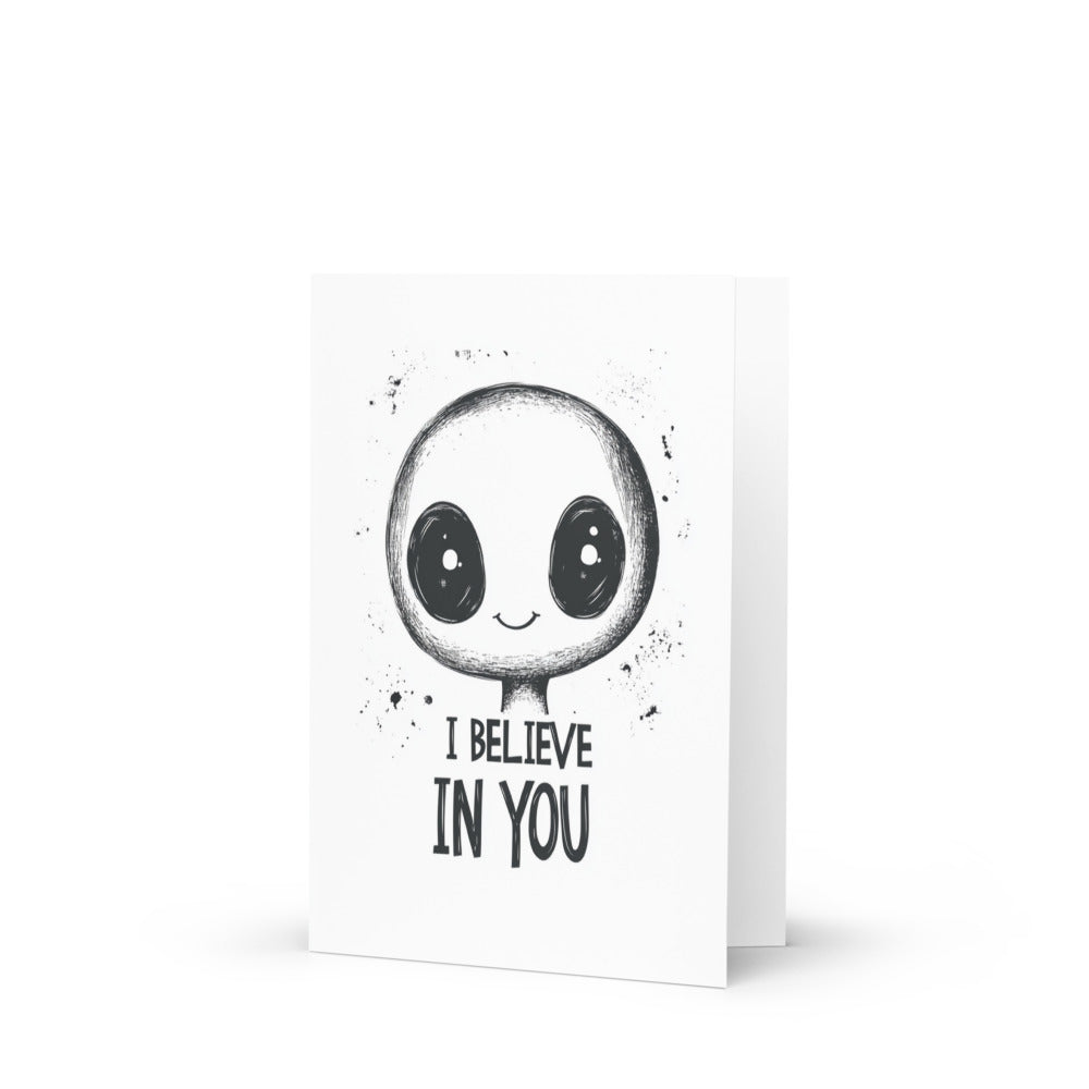 Charming Alien Greeting Card featuring a cute alien illustration with big eyes and the motivational phrase 'I believe in you' on a crisp white background, perfect for uplifting messages.