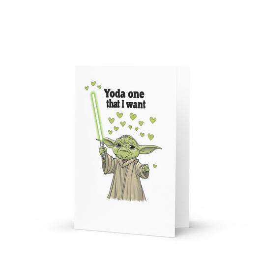 Whimsical Yoda greeting card featuring a cartoon Yoda holding a lightsaber surrounded by hearts, perfect for celebrating love and special occasions in a humorous way.