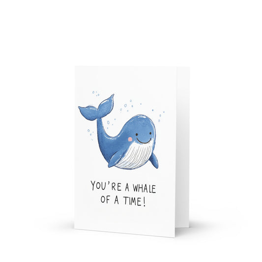 Hand-drawn blue whale greeting card featuring a cheerful whale with the text 'YOU’RE A WHALE OF A TIME!' on a minimalist white background, perfect for celebrating friendship.