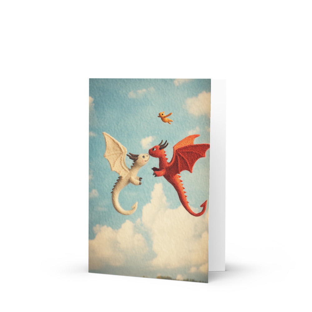 Charming congratulations card featuring playful felted dragons in a bright blue sky with fluffy clouds, perfect for celebrating a new family addition and designed by Matt & John.