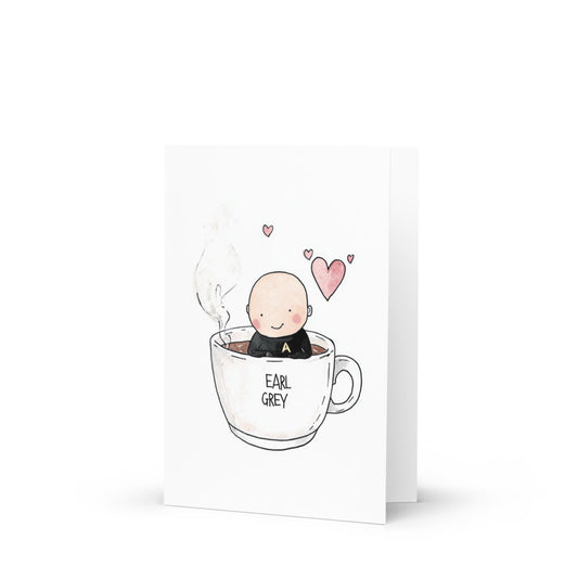 Charming Captain Picard-themed greeting card featuring a cute cartoon drawing of a character resembling Picard sitting in a giant white mug of Earl Grey tea, perfect for Star Trek fans and tea lovers.