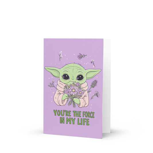 Whimsical Yoda-inspired creature holding a colorful bouquet of flowers, set against a soft lavender background, with the text 'YOU'RE THE FORCE IN MY LIFE' in playful green font, showcasing a kawaii design for greeting cards.